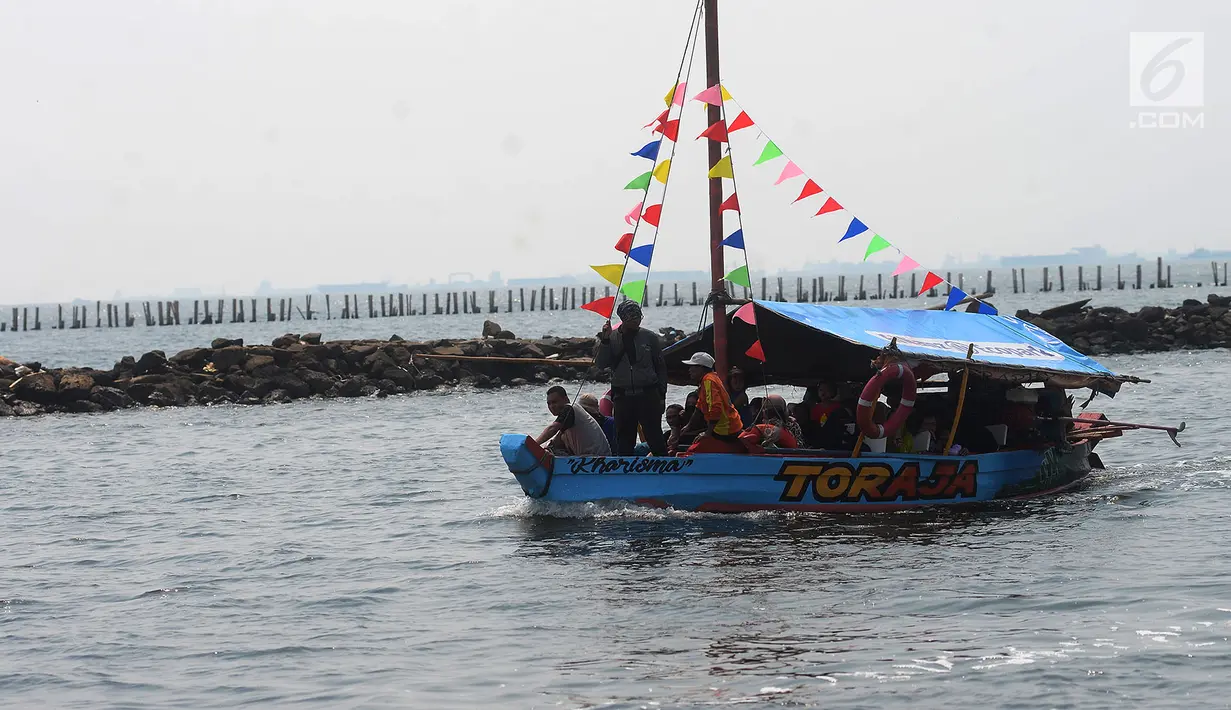Wisatawan berkeliling menggunakan perahu wisata di Pantai Ancol, Jakarta, Senin (18/6). Taman Impian Jaya Ancol masih menjadi destinasi wisata yang ramai dikunjungi saat libur Lebaran. (Merdeka.com/Imam Buhori)
