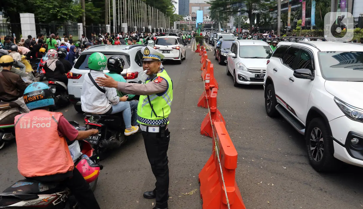 Petugas kepolisian mengatur arus lalu lintas di kawasan Sudirman, Jakarta, Rabu (15/11/2023). Menjelang konser Coldplay, terjadi kepadatan arus lalu lintas di ruas Jalan Sudirman, Gatot Subroto. (Liputan6.com/Herman Zakharia)