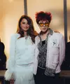 G-Dragon tampil nyentrik dalam balutan jaket tweed berwarna pink dengan aksen mutiara, kemeja ruffle bermotif dan celana hitam yang memberikan keseimbangan sempurna pada keseluruhan tampilan. Penampilannya kian stand out dengan rambut messy berwarna merah menyala. [Dok/Chanel].