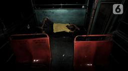 Beni (40), sopir Metromini 03 tidur di dalam bus saat menginap di pool. Karya foto ini sedang dipamerkan dalam pameran foto dengan tema ”Innovation” di Erasmus Huis. (merdeka.com/Iqbal S Nugroho)