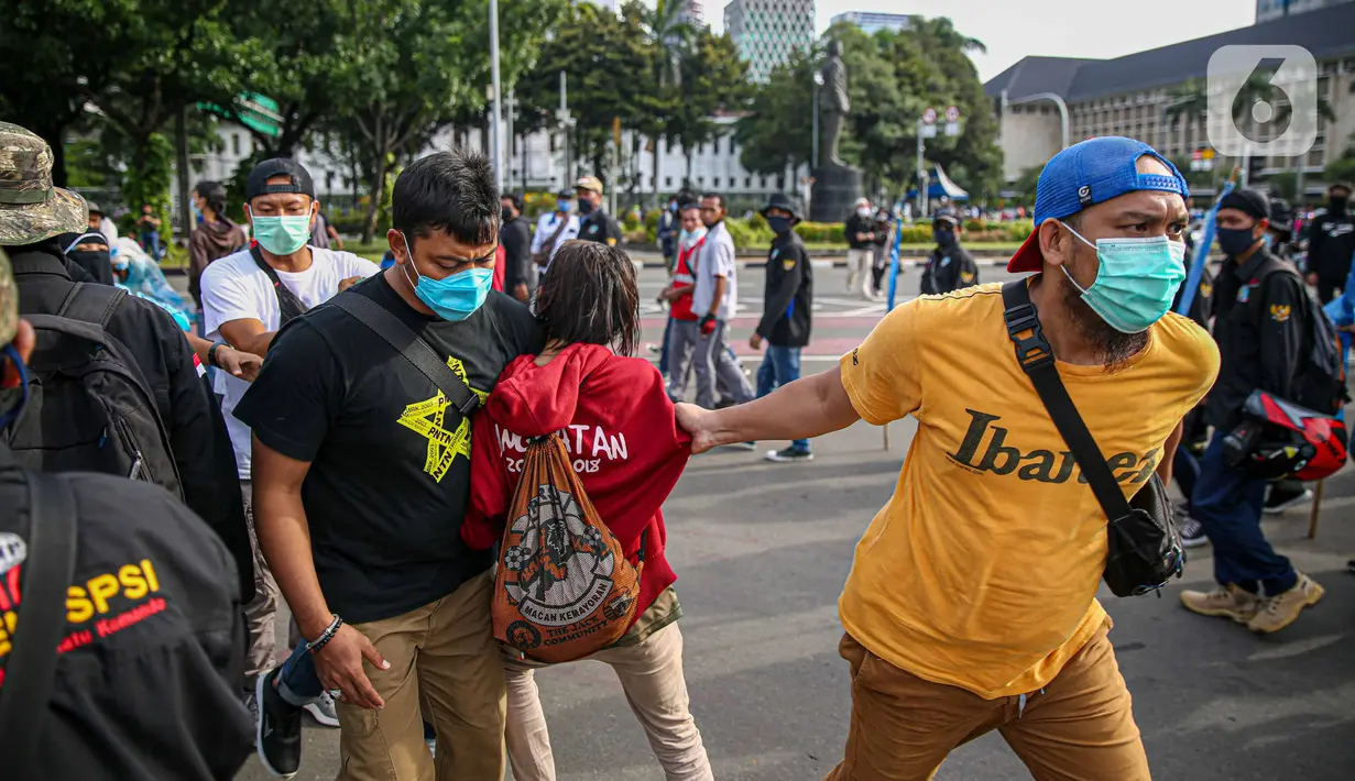 Petugas kepolisian mengamankan massa yang diduga hendak berbuat kericuhan saat aksi unjuk rasa di kawasan Patung Kuda, Jakarta, Kamis (22/10/2020). Penangkapan dilakuka  untuk mencegah hal hal yang tak di inginkan saat unjuk rasa. (Liputan6.com/Faizal Fanani)