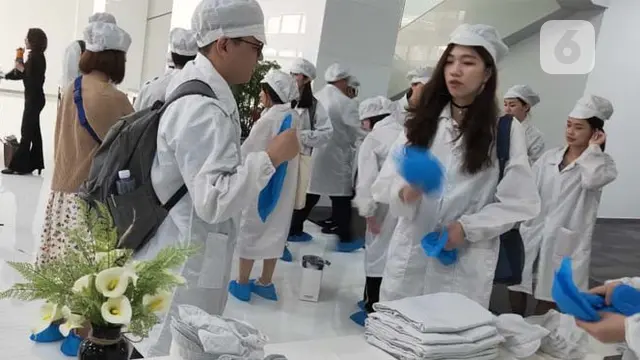 Persiapan memasuki pabrik Oppo di Dongguan, Guangdong, Tiongkok. Pengunjung mengenakan pakaian khusus, topi, dan penutup sepatu. (Liputan6.com/Ramdania El Hida)
