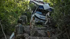 Petugas keamanan memeriksa sebuah bus yang jatuh ke jurang yang dalam pada hari Minggu setelah ditembaki oleh kelompok militan di distrik Reasi, Jammu dan Kashmir, Senin (10/6/2024). (AP Photo/Channi Anand)