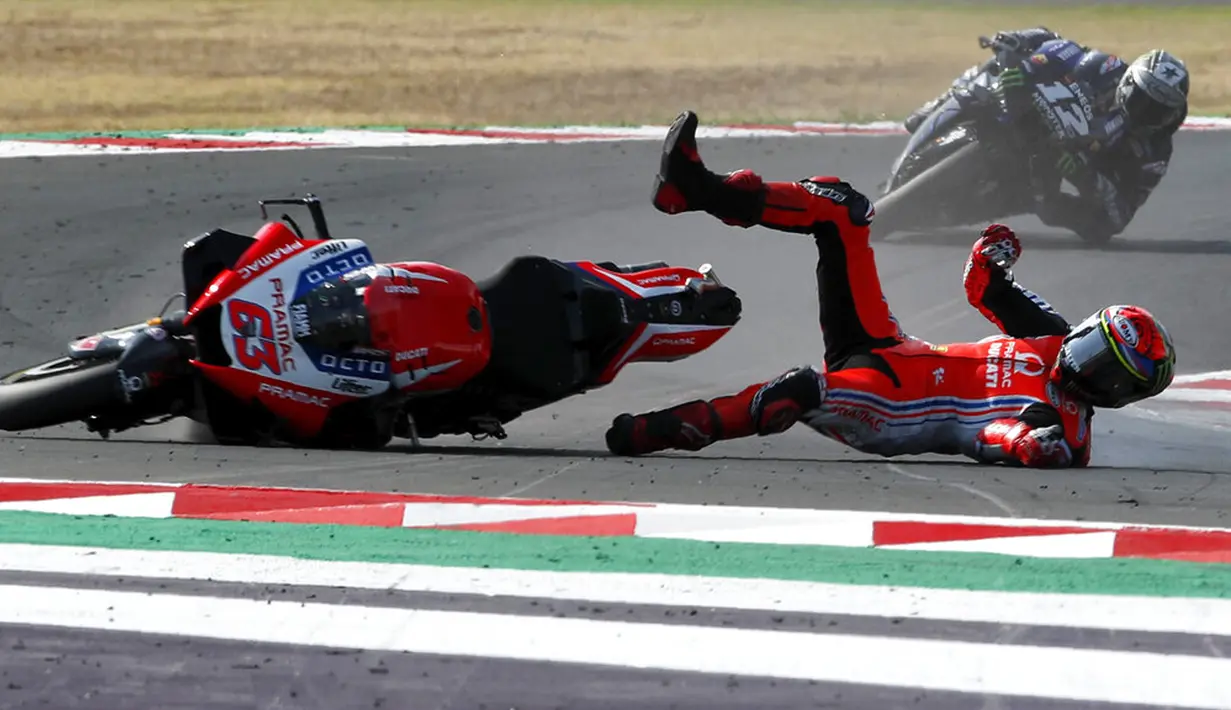Pembalap MotoGP Francesco Bagnaia terjatuh di depan Maverick Vinales saat memimpin balapan MotoGP Emilia Romagna 2020 di Sirkuit Misano, Misano Adriatico, Italia, Minggu (20/9/2020). Bagnaia terjatuh dan tak bisa melanjutkan pertandingan yang tinggal tersisa tujuh lap. (AP Photo/Antonio Calanni)
