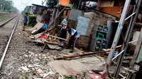 Warga membongkar bangunan rumahnya yang terletak di pinggir rel kereta api di kawasan Kelurahan Rawajati, Pancoran, Jakarta, Rabu (10/6/2015). Warga rela membongkar sendiri rumahnya karena bermukim di lahan milik PT KAI. (Liputan6.com/Helmi Afandi)