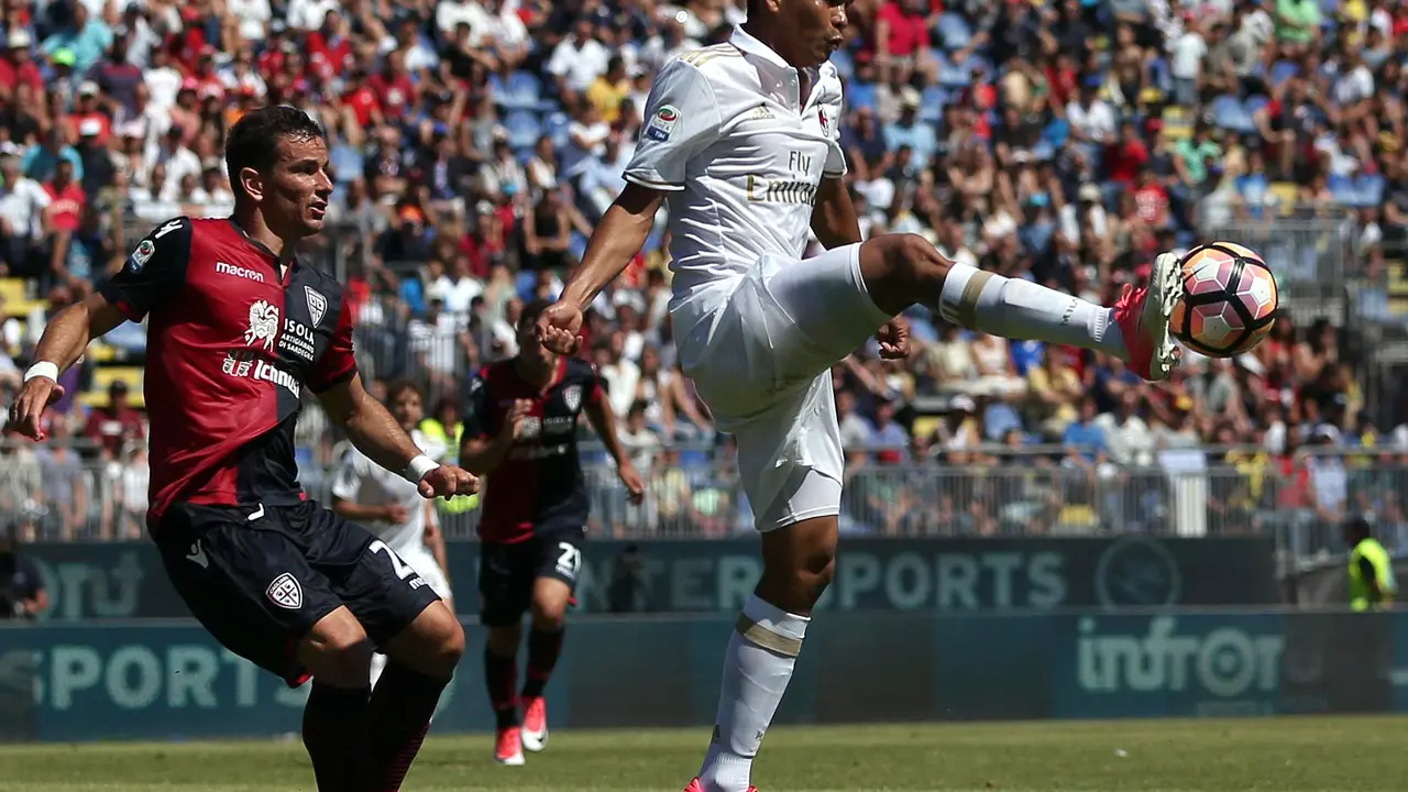 Striker AC Milan Carlos Bacca (kanan), menguasai bola pada duel melawan Cagliari di Stadio Sant'Elia, Minggu (28/5/2017).