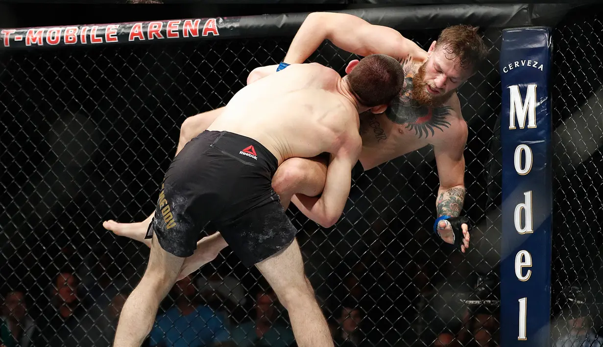 Khabib Nurmagomedov membanting Conor McGregor dalam pertarungan UFC 229 di Las Vegas, AS (6/10). Nurmagomedov mengalahkan McGregor dan berhasil keluar sebagai pemenangnya. (AP Photo/John Locher)