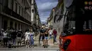 Orang-orang menunggu untuk menyeberang jalan di pusat kota Lisbon, Portugal, Senin (13/9/2021). Portugal hari ini mengakhiri aturan wajib penggunaan masker di jalan-jalan. (PATRICIA DE MELO MOREIRA / AFP)