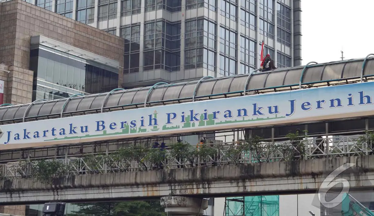 Agustinus terlihat duduk-duduk santai di atap jembatan penyeberangan orang itu. Bendera Merah Putih yang dibawanya diikatkan di besi-besi yang ada di jembatan tersebut, Jakarta, Rabu (23/07/2014) (Liputan6.com/Johan Tallo)