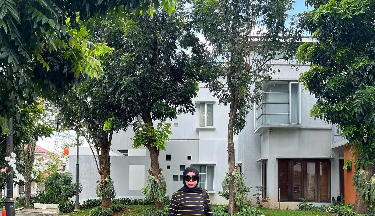 Gaya minimalis lainnya adalah dengan memakai jeans dan kaus lengan panjang motif stripes dan hijab warna hitam plus sneakers putih. [@melly_goeslaw]
