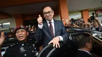Anwar Ibrahim mengacungkan jempol kepada para pendukungnya di Rumah Sakit Rehabilitasi Cheras, Kuala Lumpur. Tindakan itu mengafirmasi statusnya sebagai orang yang bebas, usai menerima pengampunan dari Raja Malaysia (16/5) (Mohd Rasfan / AFP PHOTO)
