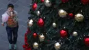 Seorang anak berjalan di dekat pohon Natal di pusat kota Beirut, Lebanon, pada 13 Desember 2020. Baru-baru ini, berbagai dekorasi Natal telah dipasang di pusat kota Beirut menyambut liburan Natal dan Tahun Baru mendatang meski sedang dilanda pandemi COVID-19 dan krisis ekonomi. (Xinhua/Bilal Jawich)