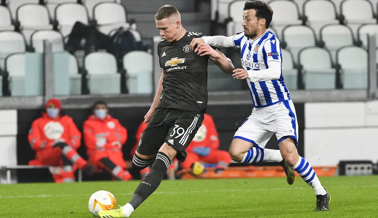 Gelandang Real Sociedad, David Silva berusaha merebut bola dari gelandang Manchester United, Scott McTomina pada leg pertama babak 32 besar Liga Europa di stadion Juventus, Turin (19/2/2021). MU menang telak atas Sociedad 4-0. (Marco Alpozzi/LaPresse via AP)