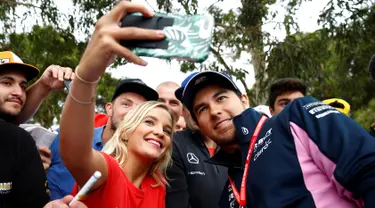 Pembalap F1 Racing Point, Sergio Perez berselfie dengan penggemarnya saat tiba di Sirkuit Melbourne Grand Prix di Melbourne, Jumat (15/3). Seri GP Australia akan menjadi pembuka ajang Formula 1 (F1) musim 2019. (Reuters/Edgar Su)