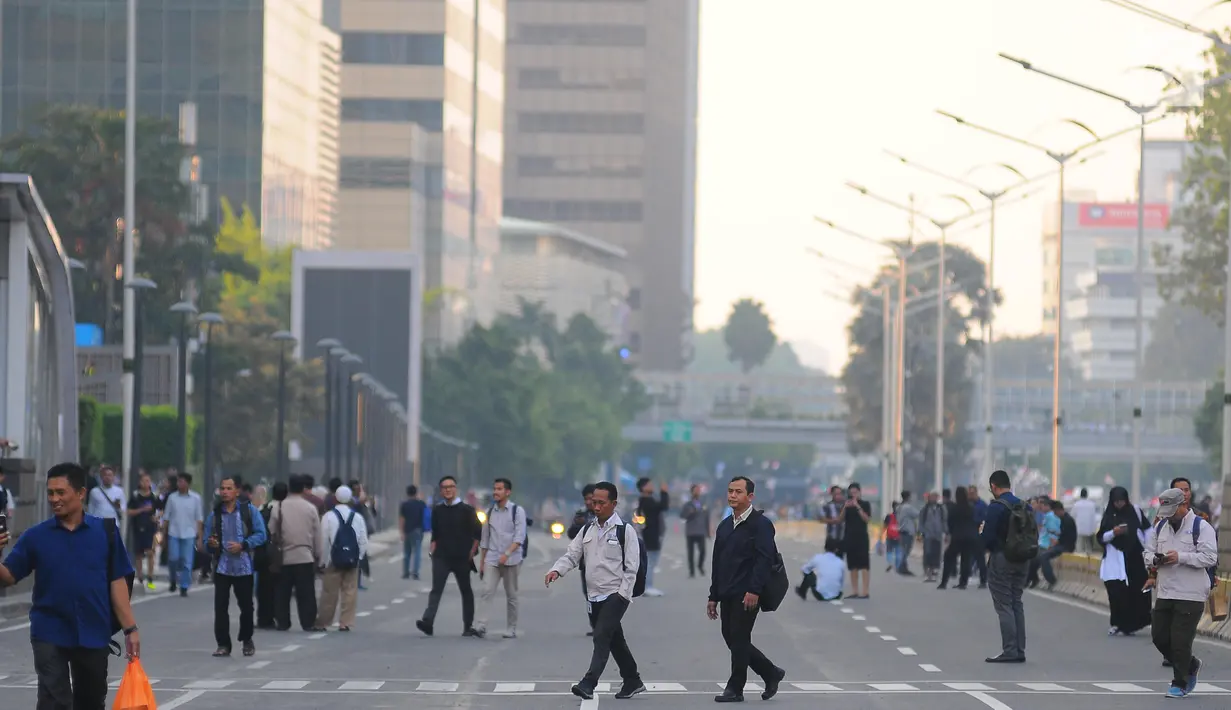 Sejumlah karyawan terpaksa berjalan kaki usai pulang kerja di kawasan Thamrin, Jakarta, Selasa (21/5). Akibat adanya aksi masa tolak hasil pemilu 2019 membuat sejumlah ruas jalan di kawasan tersebut di tutup. (Liputan6.com/Angga Yuniar)