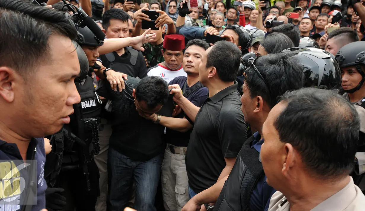 Petugas kepolisian mengamankan salah satu tersangka perampokan disertai penyanderaan di Kawasan Pondok Indah, Jakarta, Minggu (3/9). Dua tersangka pelaku perampokan disertai penyanderaan dilumpuhkan polisi. (Liputan6.com/Helmi Fithriansyah)