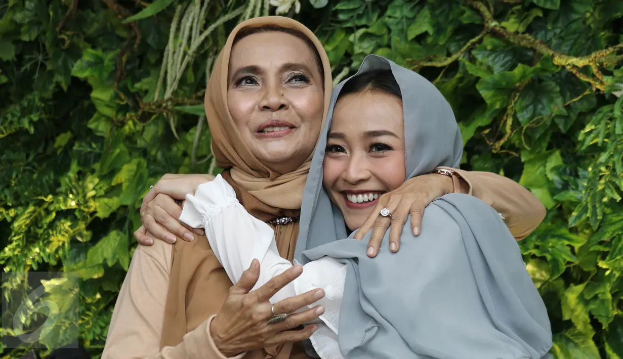 Penyanyi Rinni Wulandari bersama ibunya berpose saat  jumpa pers seusai menggelar pengajian dalam perayaan hari ulang tahun dan menjelang pernikahan di kawasan Cireundeu, Tangerang Selatan, Jumat (28/4). (Liputan6.com/Herman Zakharia)