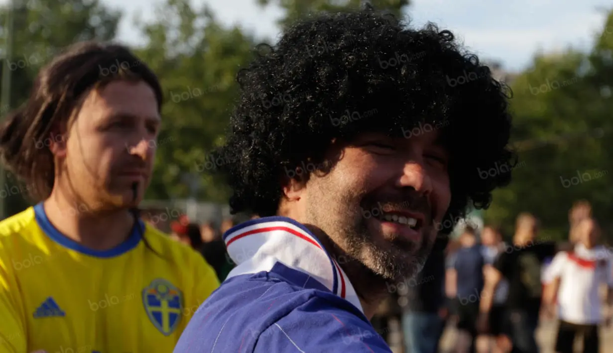 Seorang penggemar bergaya menjadi legenda hidup Prancis, Michel Platini, saat berada di fan zone Kota Paris. (Bola.com/Vitalis Yogi Trisna)