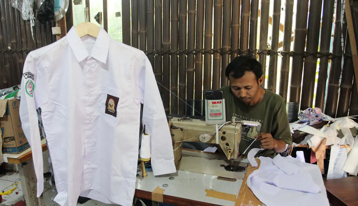 Pekerja menyelesaikan produksi seragam sekolah di rumah ronveksi Fia Busana Sawangan Depok, Jawa Barat, Rabu (08/07/2026). (KLY/ Arie Basuki)