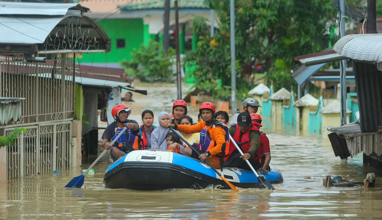 Tim penyelamat mengevakuasi warga di tengah banjir akibat hujan deras semalam di Medan, Sumatera Utara (4/12/2020). Sebelumnya banjir setinggi kurang lebih 1 meter terakhir kali pernah terjadi pada 2001. (AFP/Rahmad Suryadi)