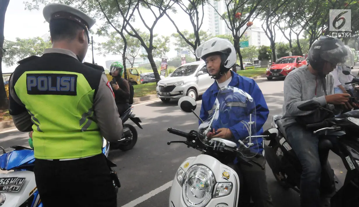 Anggota Satlantas Polres Tangerang Selatan memeriksa kelengkapan surat saat razia pajak kendaraan di Jalan BSD, Tangerang Selatan, Kamis (24/1). Razia ini untuk mendisiplinkan pengendara terhadap pembayaran pajak kendaran. (Merdeka.com/Arie Basuki)