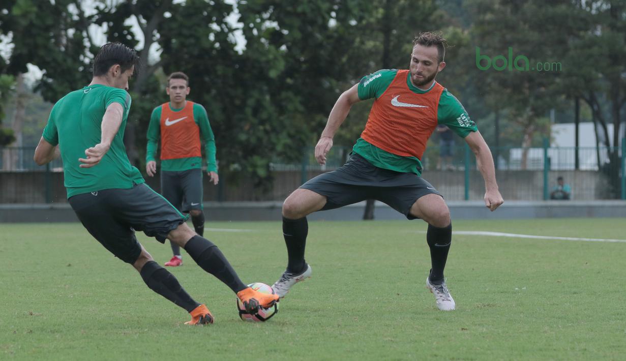 Ilija Spasojevic (kanan) saat berebut bola dengan rekannya Gavin Kwan saat berlatih di Lapangan ABC, Senayan,  (24/4/2018). Timnas akan mengikuti turnamen PSSI Anniversary 27 April-3 Mei 2018. (Bola.com/Nicklas Hanoatubun)