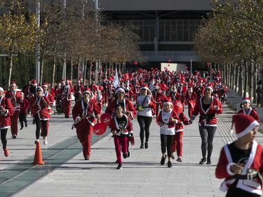Orang-orang yang mengenakan kostum Sinterklas mengikuti Athena Santa Run, di Athena, Yunani, Minggu (12/12/2021). Ratusan orang berpartisipasi mengikuti lomba lari untuk acara amal di area sekitar kompleks Stadion Olimpiade Athena. (AP Photo/Yorgos Karahalis)