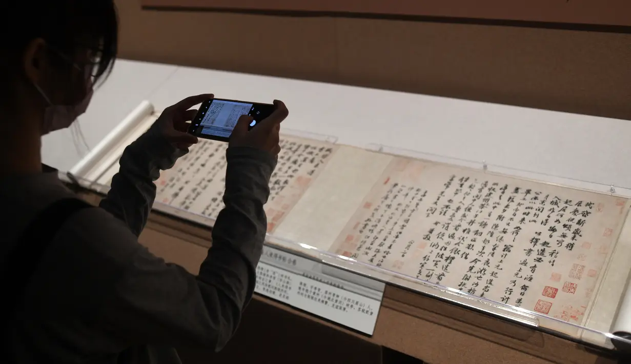 Pengunjung memotret benda saat konferensi pers pameran kaligrafi dan lukisan Su Shi di Museum Istana, Beijing, China, 31 Agustus 2020. Pameran kaligrafi dan lukisan Su Shi akan digelar pada 1 September hingga 30 Oktober. (Xinhua/Jin Liangkuai)