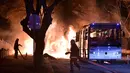 Petugas pemadam bersiap memadamkan api setelah ledakan bom mobil di Ankara, Turki, Rabu (17/2). Bom mobil yang meledak ketika iring-iringan bus militer tengah lewat tersebut menewaskan setidaknya 28 orang.  (REUTERS/Ihlas News Agency TURKEY OUT)