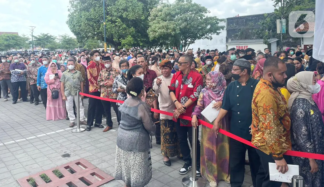 Anrean para tamu untuk memasuki lokasi resepsi pernikahan putra bungsu Presiden Jokowi, Kaesang Pangarep dan Erina Gudono di Pura Mangkunegaran Solo, Jawa Tengah, Minggu (11/12/2022). Setelah turun dari bus, para tamu langsung berjalan kaki menuju tempat pengecekan tamu undangan di sebelah barat pintu masuk Pura Mangkunegaran. (Liputan6.com/Herman Zakharia)
