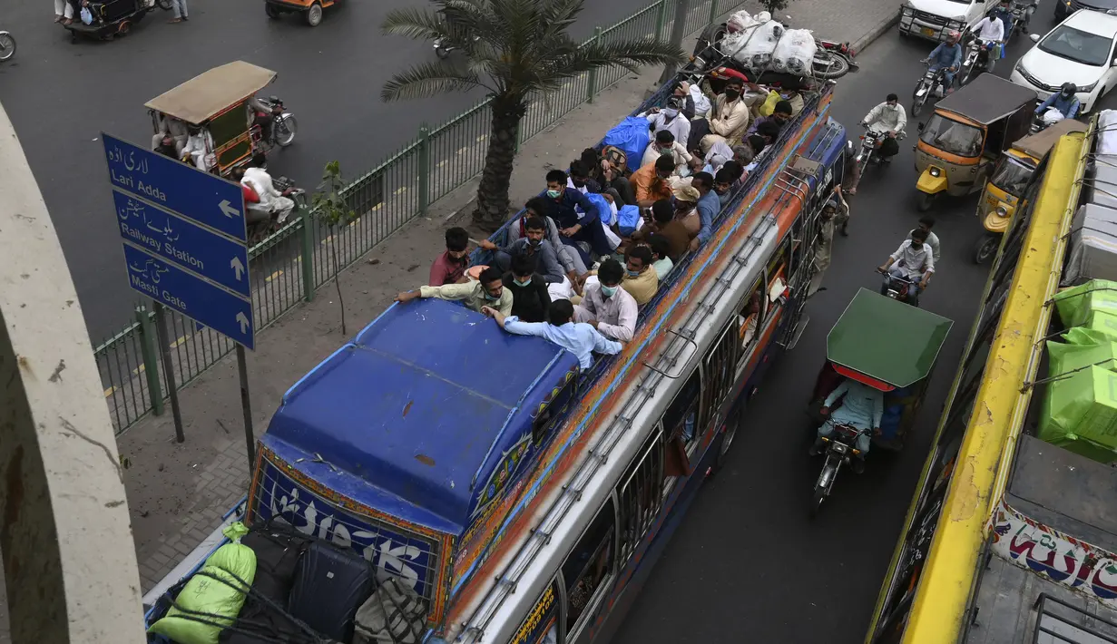 Warga berada di bus saat mereka melakukan perjalanan ke kampung halaman mereka menjelang perayaan Idul Fitri di Lahore (7/5/2021). Lebaran Idul Fitri jatuh pada 13 Mei 2021. (AFP Photo/Arif Ali)