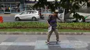 Pejalan kaki bermain skate board di trotoar sekitar Halte Gelora Bung Karno, Jakarta, Jumat (17/5/2019). Koalisi Pejalan Kaki melakukan eksperimen permainan untuk mengedukasi kegiatan mengembalikan fungsi trotoar lebih dari sekedar ruang berjalan kaki. (Liputan6.com/Helmi Fithriansyah)