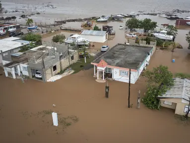 Rumah-rumah terendam banjir di Pantai Salinas setelah lewatnya Badai Fiona di Salinas, Puerto Rico, Senin, 19 September 2022. Badai Fiona yang menerjang Puerto Rico menyebabkan banjir dan tanah longsor. (AP Photo/Alejandro Granadillo)