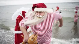 Seorang peserta Kongres Santa Claus Dunia 2015 bersiap berenang di pantai Bellevue di Copenhagen, Denmark, Minggu (21/7/2015). (REUTERS/Scanpix Denmark/Erik Refner)
