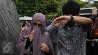 Istri Hakim MK Patrialis Akbar, Sufriyeni (kiri) saat menuju ruang tahanan KPK, Jakarta, Senin (30/1). Kedatangannya untuk menjenguk Patrialis Akbar yang ditahan sebagai tersangka dugaan penerima suap uji materi UU. (Liputan6.com/Helmi Fithriansyah)