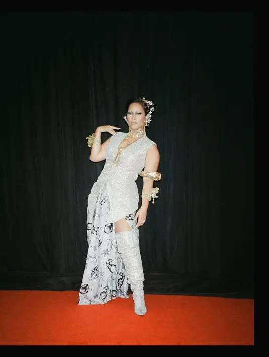 Tara Basro tampil futuristic edgy dengan batik di gelaran FFI 2022. Ia padukan vest sequin silver dengan kain Batik putih yang dijadikan rok slit. High boots sequin bikin tampilannya makin statement [@tarabasro]