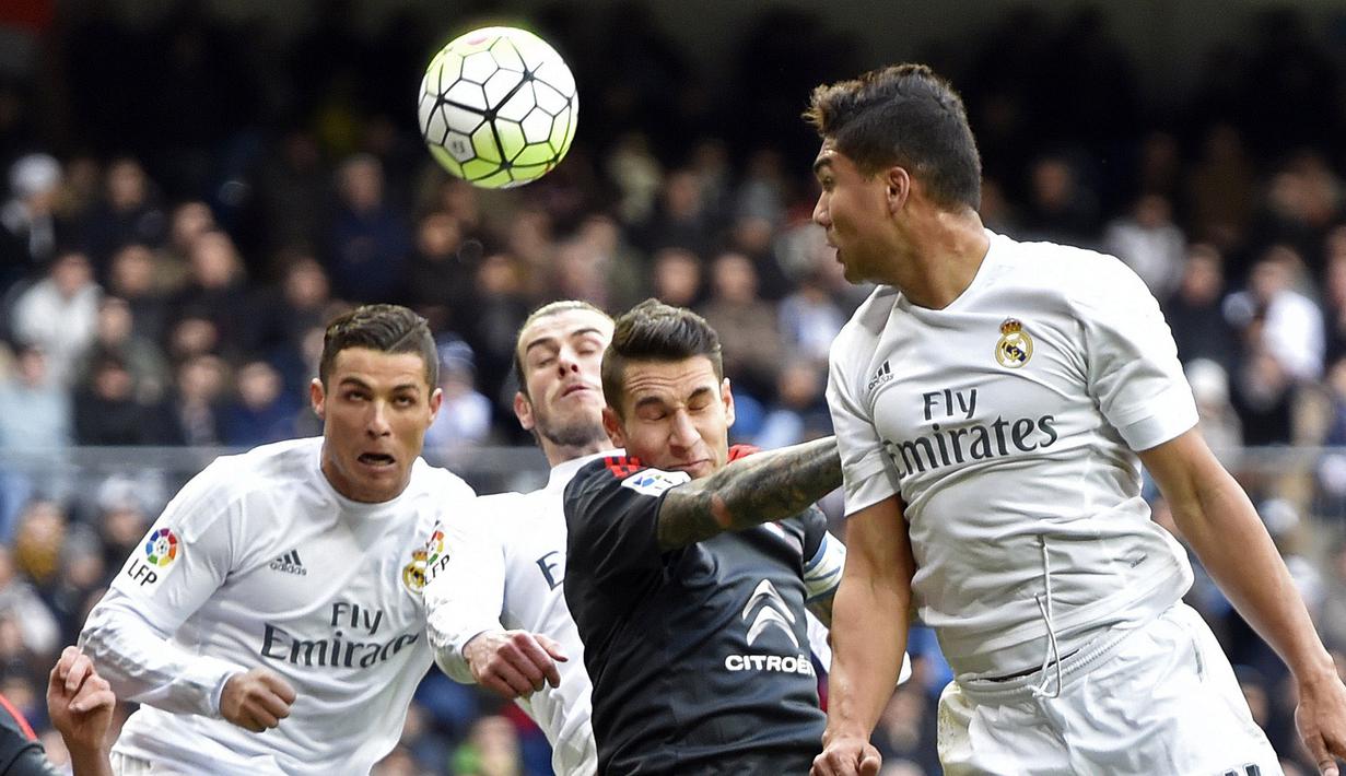 Pemain Real Madrid, Cristiano Ronaldo (kiri) berusaha menyundul bola dari hadangan pemain Celta de Vigo pada lanjutan La Liga Spanyol di Stadion Santiago Bernabeu , Madrid, Sabtu (5/3/2016). (AFP/Gerard Julien)