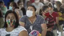 Sejumlah wanita duduk setelah menerima sumbangan pembalut dan perlengkapan kebersihan perempuan lainnya di tengah pandemi COVID-19 di favela Paraisopolis, di Sao Paulo, Brasil (24/5/2021). Sumbangan ini disediakan oleh LSM lokal "G10 Favelas". (AP Photo/Andre Penner)