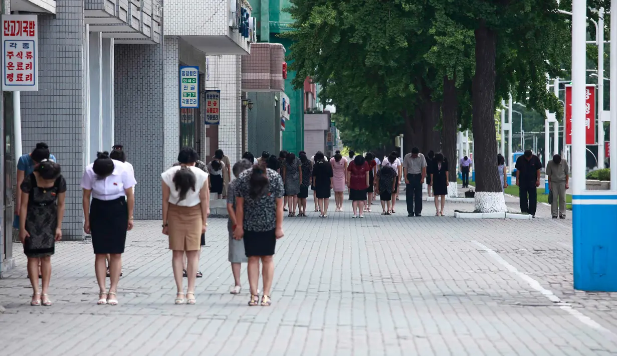Pra pria dan wanita membungkukkan badan mereka saat memberi penghormatan selama tiga menit dalam peringatan 25 tahun meniggalnya pemimpin Kim Il Sung di Pyongyang, Korea Utara, Senin(8/7/2019). (AP Photo/Cha Song Ho)