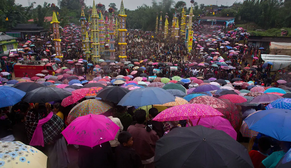 Ratusan warga dari suku India Pnar membawa payung saat menonton Festival Behdienkhlam di desa Tuber, India (24/7). Festival Behdienkhlam adalah tradisi setempat di kawasan Meghalaya yang digelar setiap tahun. (AP Photo/Anupam Nath)