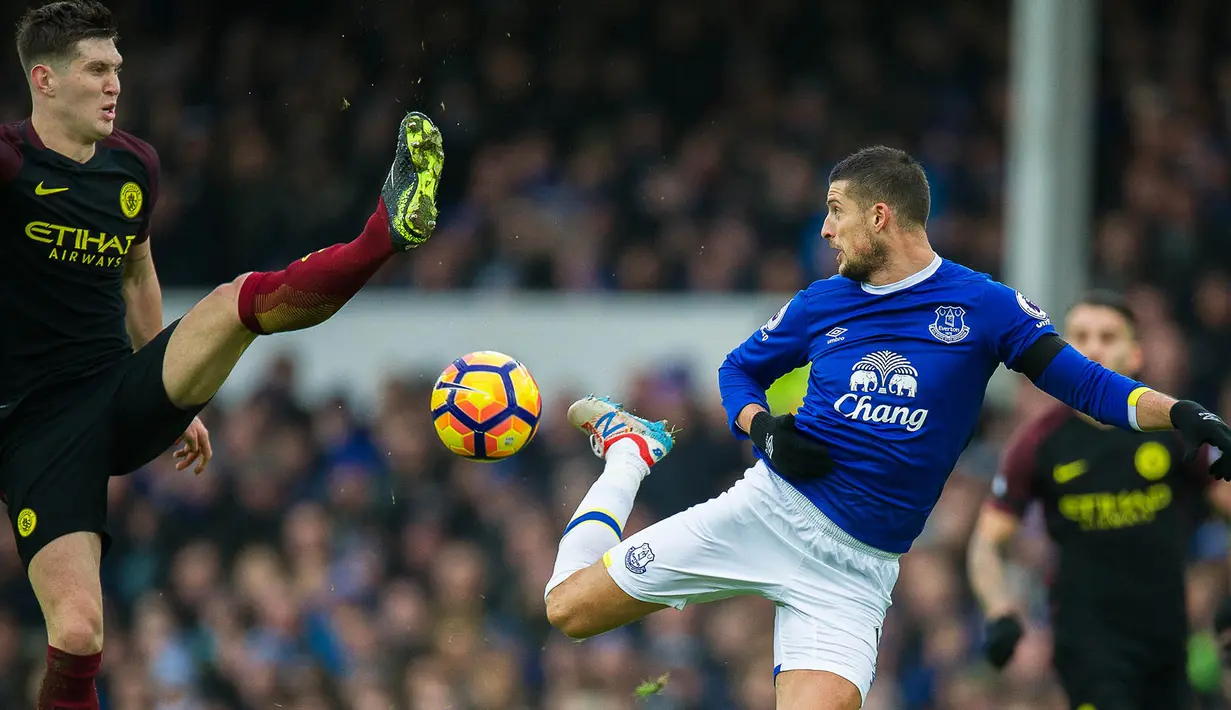 Gelandang Everton, Kevin Mirallas, berebut bola dengan bek Manchester City, John Stones. Meski kalah, City lebih menguasi jalannya laga dengan penguasaan bola mencapai 70 persen. (EPA/Peter Powell)