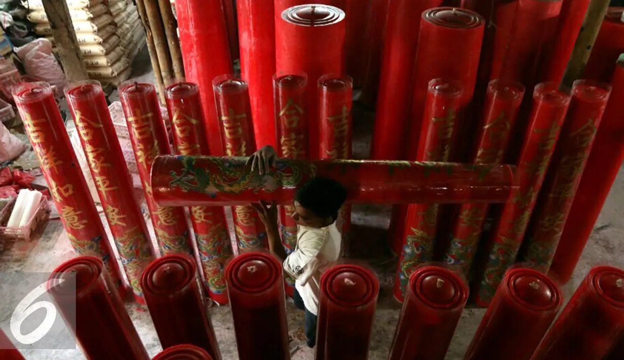 Seorang pekerja membawa lilin yang sudah jadi di industri rumahan, Di Tangerang, Rabu (4/1). Dalam rangka menyambut Imlek produksi dikebut hingga mencapai 300 batang hio perhari. (Liputan6.com/Angga Yuniar)