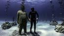 Penyelam bebas Angels Savvas berpose dengan patung di taman patung bawah laut MUSAM, Ayia Napa, Siprus, 18 September 2021. MUSAM disebut sebagai hutan bawah laut pertama di dunia. (EMILY IRVING-SWIFT/AFP)