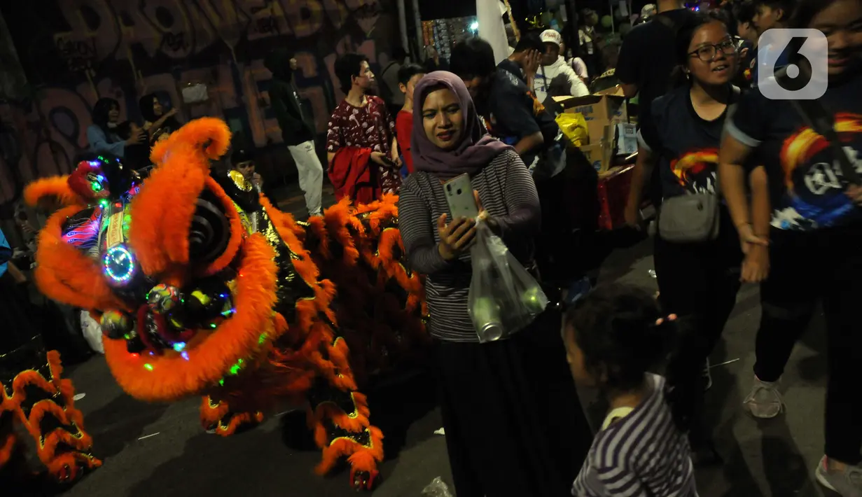 Warga menyaksikan pawai Bogor Street Festival Cap Go Meh (CGM) 2020 yang digelar di Jalan Surya Kencana, Kota Bogor, Jawa Barat, Sabtu (8/2/2020). Festival bertema "Ajang Budaya Pemersatu Bangsa" dimeriahkan 25 kelompok barongsai-liong dan beragam tarian daerah. (Liputan6.com/Helmi Fithriansyah)