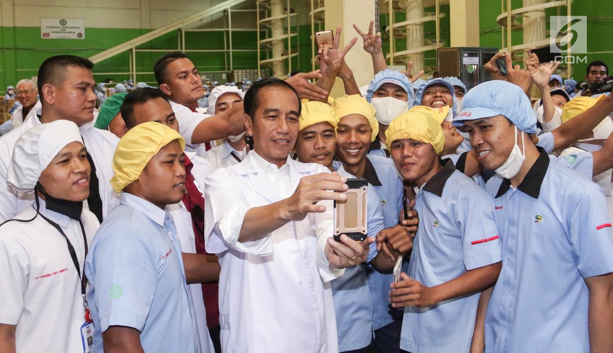 Presiden Jokowi bersama karyawan saat berswafoto di pabrik Mayora di Cikupa Tangerang, Senin (18/2). Presiden Jokowi secara resmi melepas kontainer ekspor ke 250.000 ke Filipina dan memperingati HUT Mayora Group yang ke 42. (Liputan6.com/Fery Pradolo)