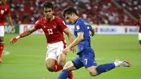 Pemain Thailand, Supachok Sarachat (kanan), mencoba melepaskan diri dari pengawalan gelandang Timnas Indonesia, Rachmat Irianto, pada leg pertama final Piala AFF 2020 di National Stadium, Singapura, Rabu (29/12/2021) malam WIB. (AP Photo/Suhaimi Abdullah)