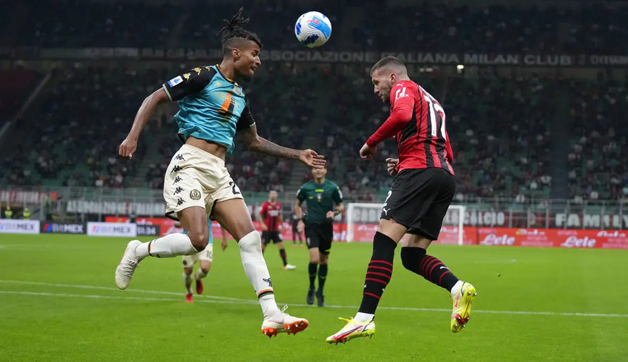 Penyerang AC Milan, Ante Rebic berebut bola dengan bek Venezia, Tyronne Ebuehi pada laga pekan ke-5 Serie A 2021/22 di San Siro, Kamis (23/9/2021) dini hari WIB. AC Milan Milan menaklukkan tamunya Venezia 2-0. (AP Photo/Antonio Calanni)