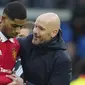 Pelatih Manchester United, Erik ten Hag tersenyum dengan Marcus Rashford saat melawan Leeds United pada laga Liga Inggris di Stadion Elland Road, Minggu (12/2/2023). Gol yang dicetaknya di Elland Road itu menjadi gol ke-13 dari 15 pertandingan yang dijalani Marcus Rashford setelah Piala Dunia 2022. (AP Photo/Jon Super)