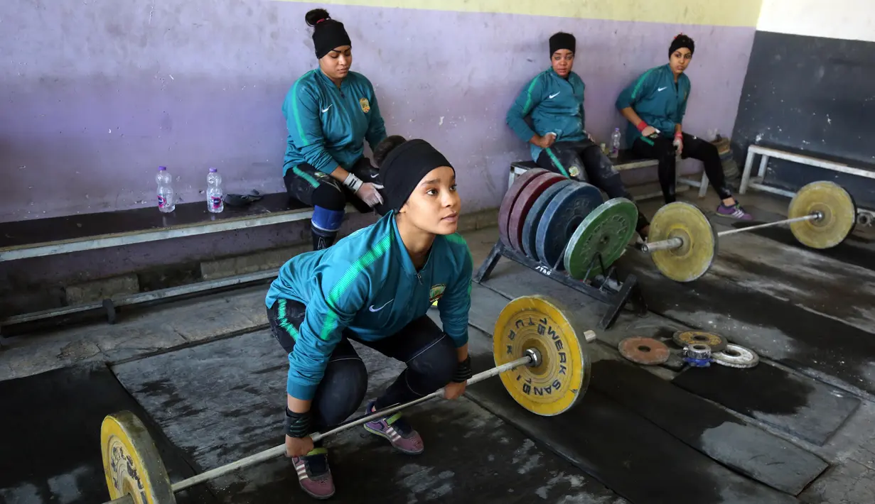 Atlet angkat besi wanita Irak Hadeel Salem Al-Saedi berlatih di sebuah klub di Kota Sadr, sebelah timur Baghdad, Irak (18/1). Para atlet wanita ini berlatih dengan giat tiap harinya. (AFP Photo/Ahmad Al-Rubaye)