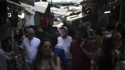 Orang Israel berjalan di pasar di Tel Aviv, Minggu (18/4/2021). Israel mencabut aturan wajib masker di ruang publik luar ruangan dan membuka kembali sekolah sepenuhnya dalam upaya menuju normalisasi setelah kampanye vaksinasi Covid-19 berjalan sukses. (AP Photo/Sebastian Scheiner)